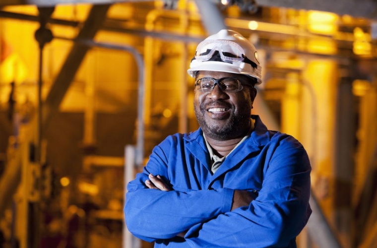 male worker in a hard hat with a smile and crossed arms